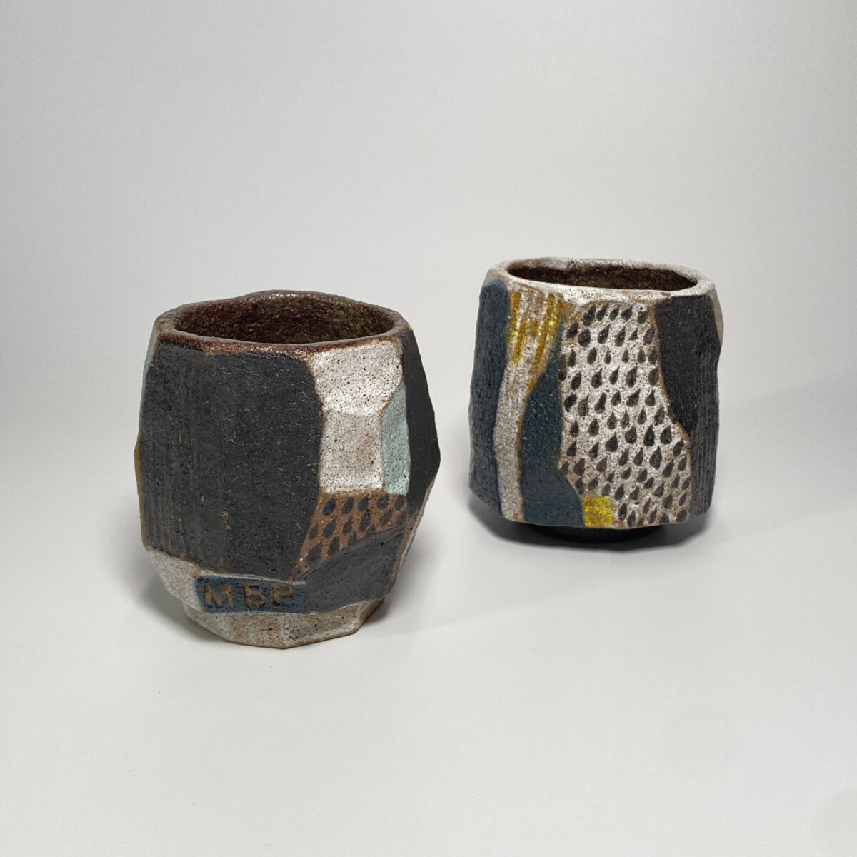 Abstract ceramic teacup geometric angles black glaze yellow speckles
