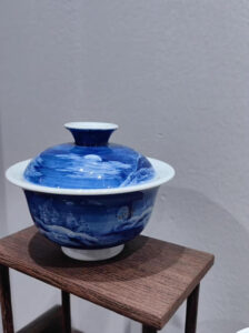 Tea leaves unfurling in blue-and-white snowscape bowl